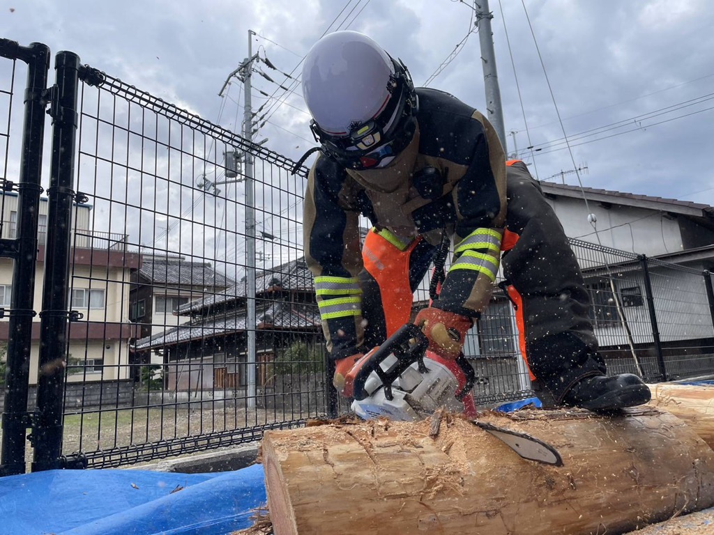 チェーンソーで木を切っている